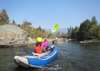 A kayaker navigates through boulders on the South Fork Trintiy River.