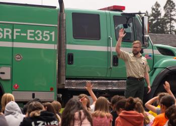 Forest staff in front of fire truck presenting to group of students