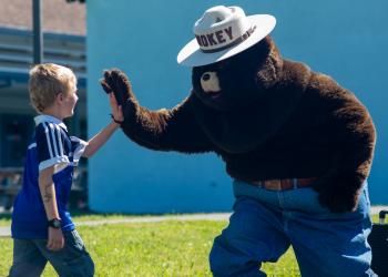 Smokey Bear giving child high five
