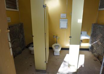 View of the inside of the Eagle Creek trailhead restroom on the women's side. The bathrooms has 2 flush toilets in stalls and a sink. This is closed in the winter. 