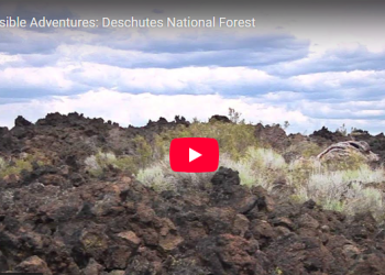 Lava rocks within arid landscape with youtube play button on top.