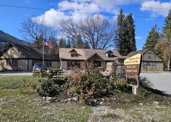 A tan and brown office sign in front of the Wenatchee River Ranger District office in Leavenworth, Washington.