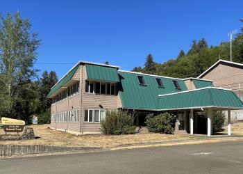 An office with a green roof and brown siding