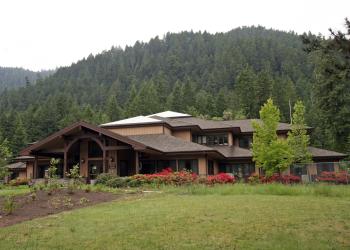 A building sits in front of a tree covered hill
