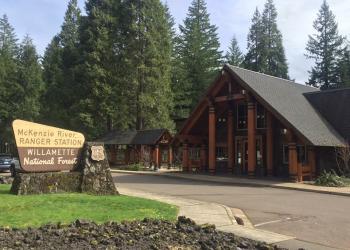 A wood building in front of trees