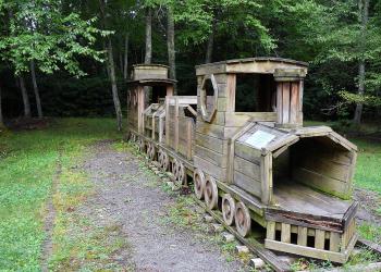 A wooden train large enough for children to play on. 