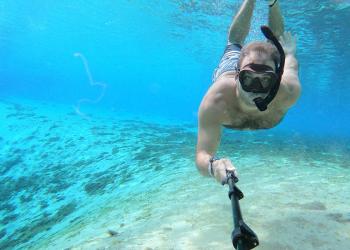 man snorkeling in blue water