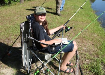 youth fishing from bank in a lawnchair
