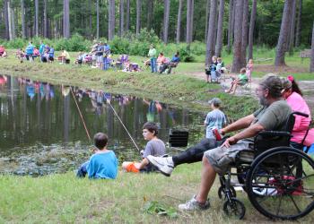 people on lake bank fishing
