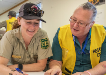 2 forest service employees looking over excel sheet 