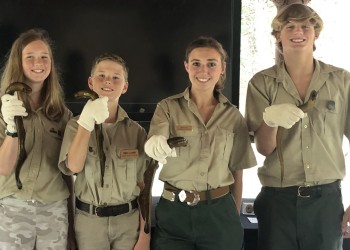 Four Forest Service employees holding lampreys. 