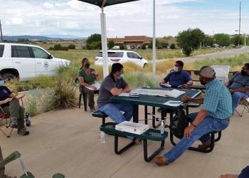 People sitting around a table outside.