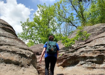 A person walking up a set of stairs placed in the middle of the rocks. 