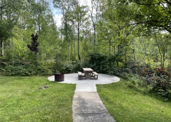 photo of a picnic table and fire ring on a concrete pad