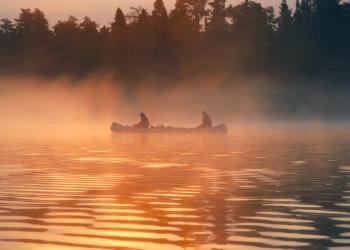 a canoe on the water at sunrise in the Boundary Waters Canoe Area Wilderness