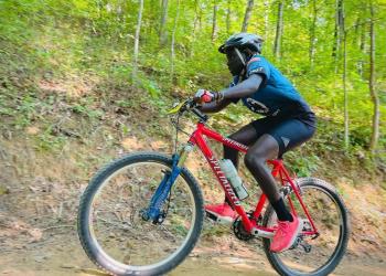 A man rides a mountain bike up a hill.