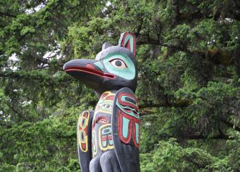 A totem pole in the woods.