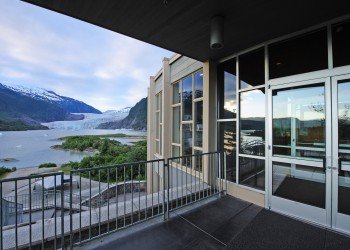 Looking out over the glacier, to the right, glass windows and doors, to the front railing
