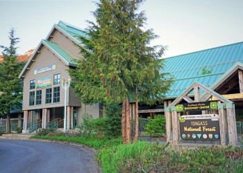 SEADC Ketchikan building with green roof, green trees out front, brown, white, green, blue  signage