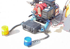 The complete system, consisting of the pump, battery pack, receiver and 2 flashing strobe beacons. The strobes are connected with extendable, coiled cord allowing them to be placed where they are most conspicuous.