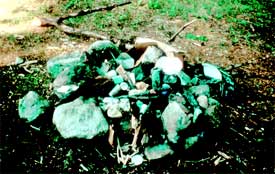 Photo of a campfire with trash on top of it.