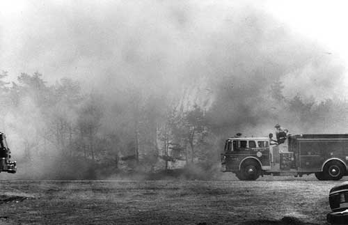 A photo of a fire engine at a forest fire.