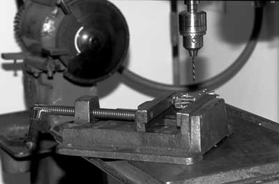Photo of the Kant-Twist clamp secured in a vise under a drill press.