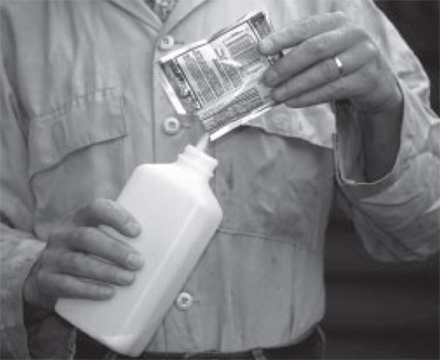 Image of a man pouring a powdered sports drink into a bottle of water.