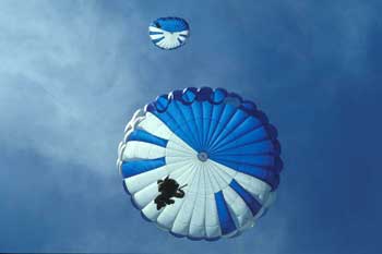 A photo of two parachutes taken from the ground looking up at them.