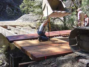 photo of man working on deck panels on bridge