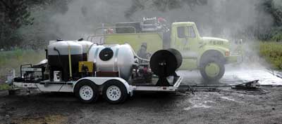 Photo of a portable vehicle washer, developed by MTDC,  being used to clean a fire engine on the Bitterroot National Forest. 