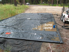 [photo] A sump pump draining water from a containment mat.