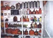 Photo of drip torches and gas cans on shelves.