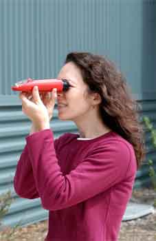 Photo of a woman looking through a refractometer.
