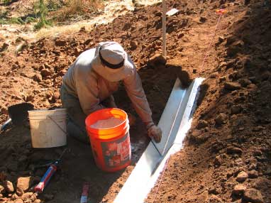 Photo of a worker placing a section of the trough in the trench.
