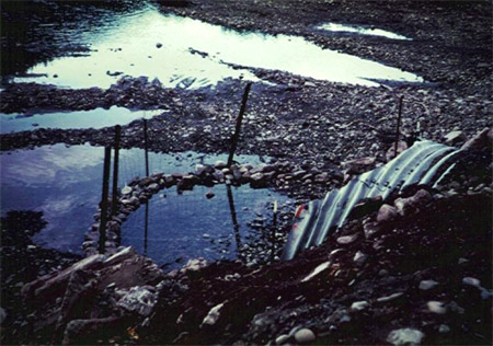 A photo of a fence built in front of a culvert.