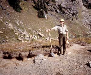 Photo of a worker standing next to an eroding plot of sod.