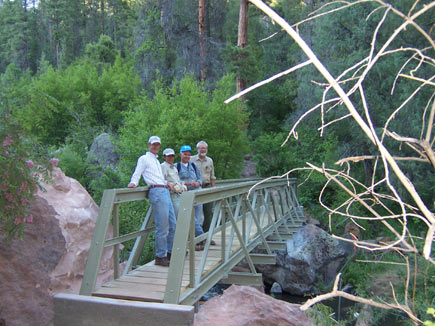 Image of four people standing on a fiber-reinforced polymer trail bridge.