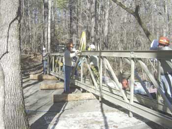Photo of workers assembling trusses in an upright position.