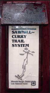 Photo of a sign with a map on it for the Sawmill-Curry Trail System.