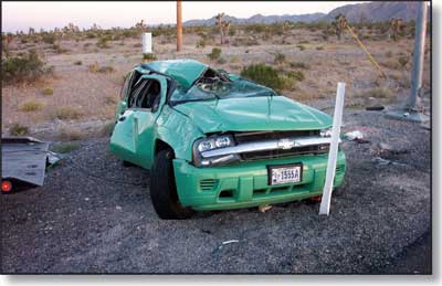 Photo of a green Forest Service vehicle that has rolled.