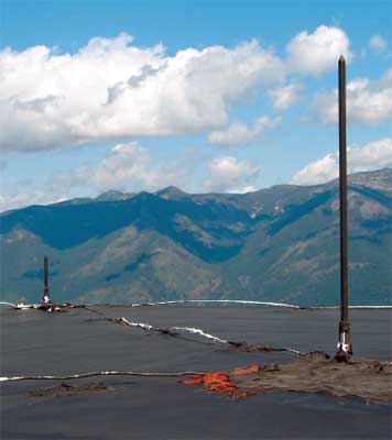 Photo of the top of a roof with two copper rods sticking up out of the roof.