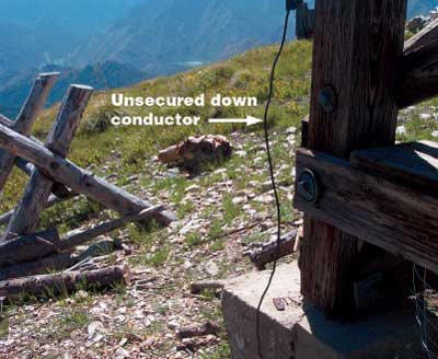 Photo of an unsecured down conductor on a wooden frame.
