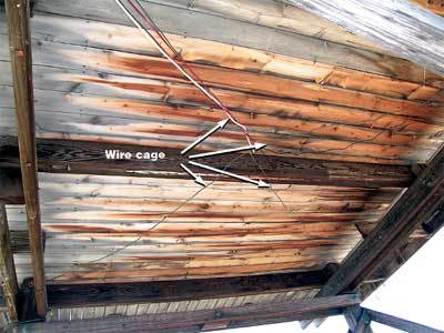 Photo of the underside of the floor of a lookout cabin with cage wire on it.