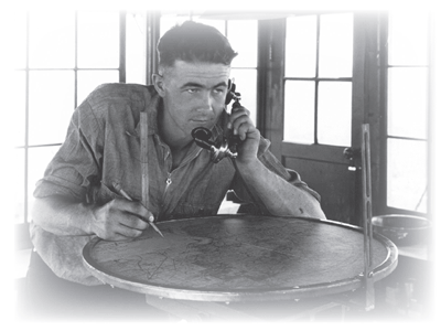 Photo of a man on the telephone looking at a map.