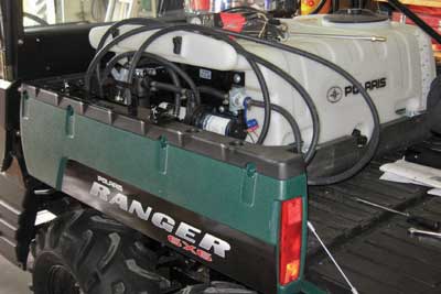 Photograph of the bed of a UTV equipped with a pesticide sprayer.