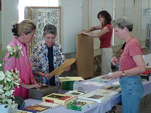 four women preparing publications and displays for a wildflower show.