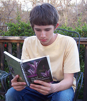 young man reading Selected Rare Plants of Northern California.